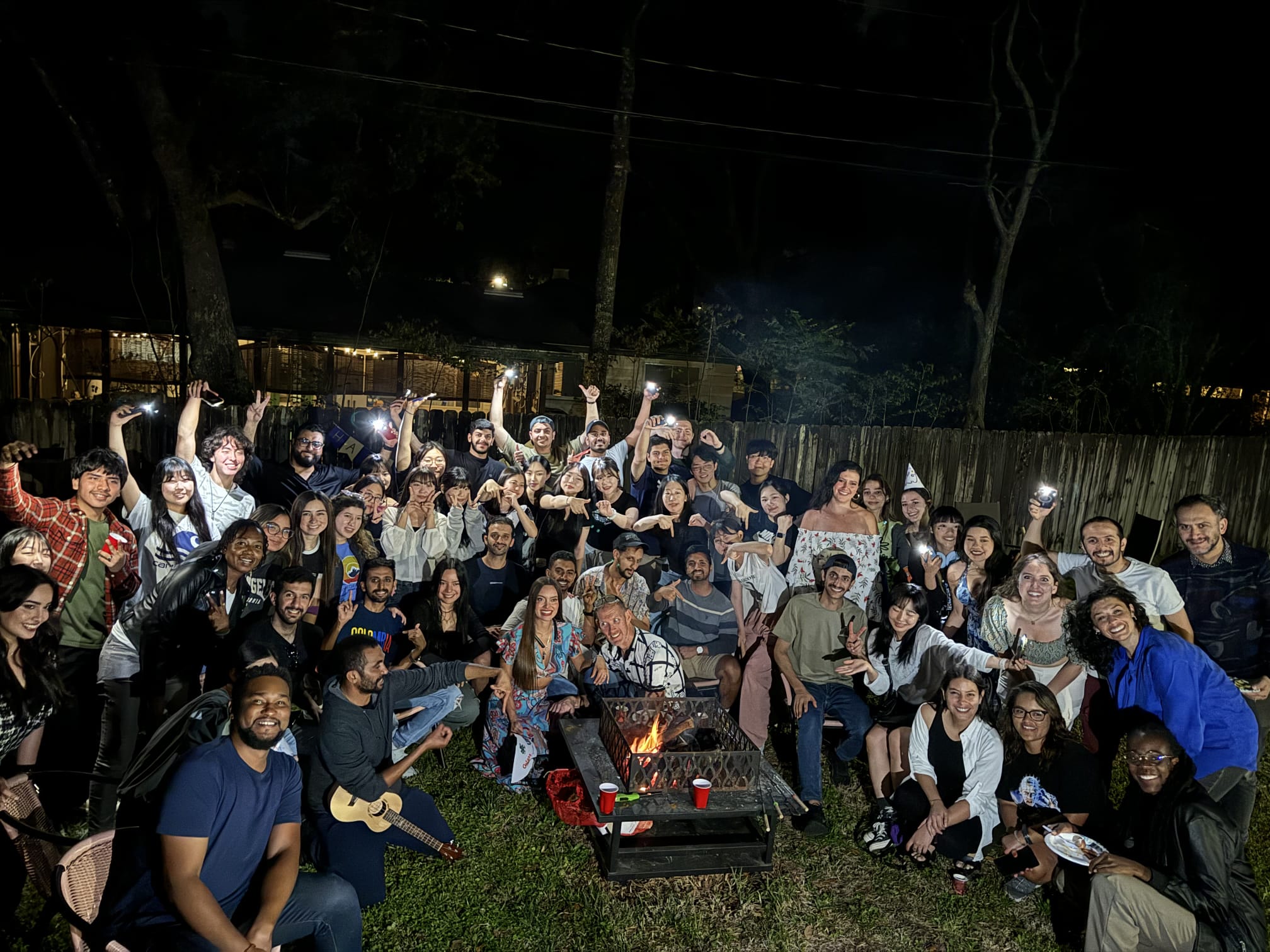 50+ international students outside around a fire celebrating 70 years of the English Language Institute.