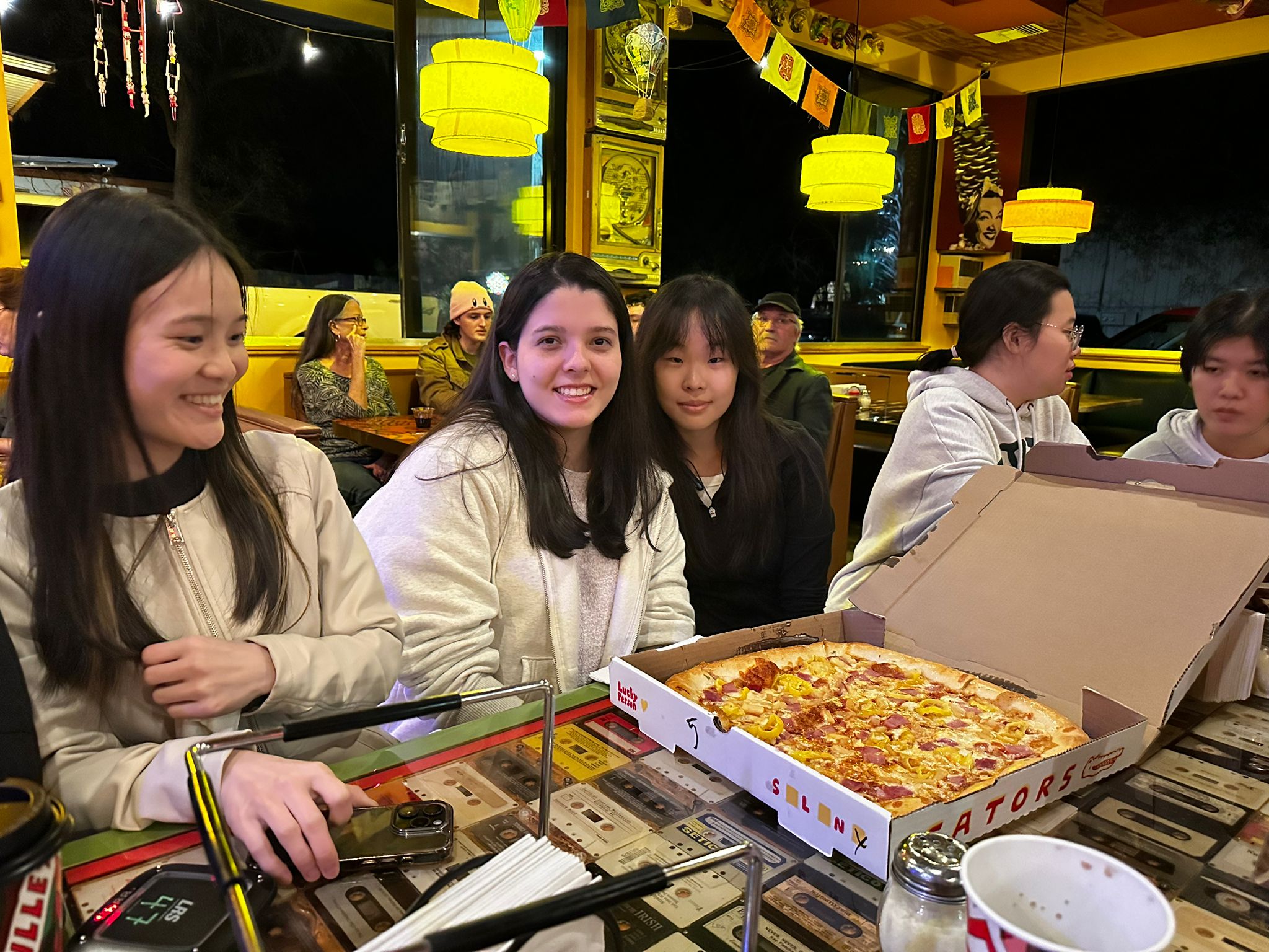 Hungry students looking at a large delicious Satchel's pizza